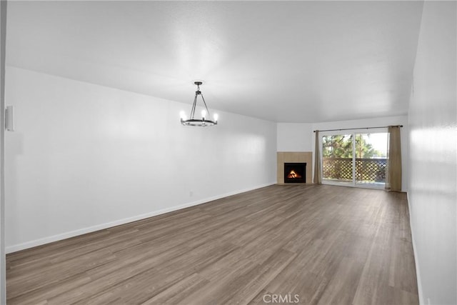 unfurnished living room with a chandelier and wood-type flooring