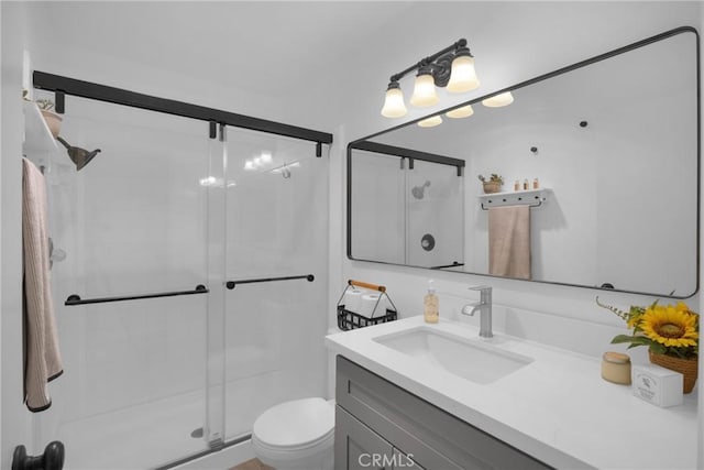 bathroom with walk in shower, vanity, and toilet