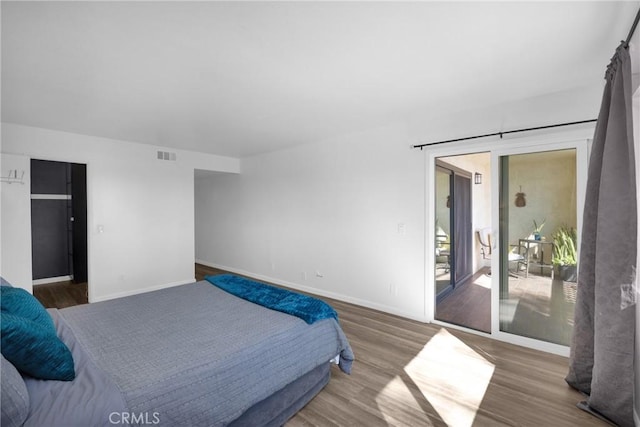 bedroom featuring dark wood-type flooring and access to exterior