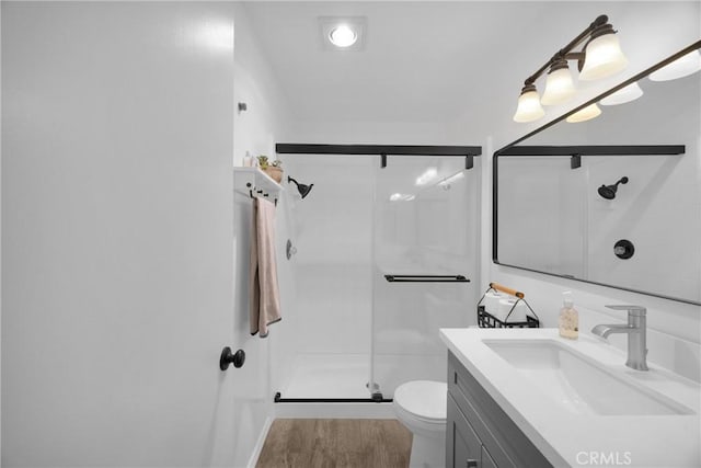 bathroom with toilet, a shower with shower door, and vanity