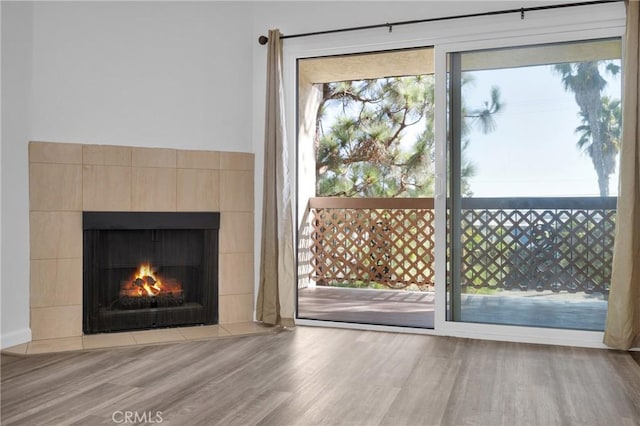 interior space featuring light hardwood / wood-style floors and a tiled fireplace