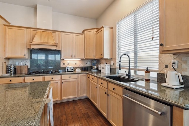 kitchen featuring dishwasher, dark hardwood / wood-style flooring, sink, and dark stone counters