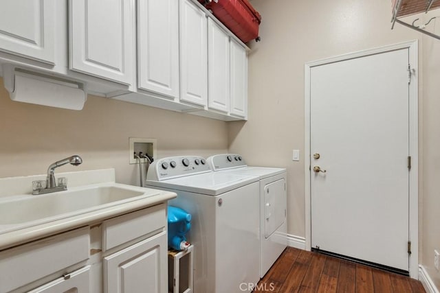 laundry room with cabinets, dark hardwood / wood-style flooring, sink, and washing machine and dryer