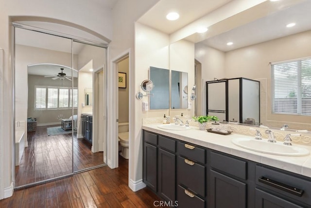 bathroom with hardwood / wood-style floors, ceiling fan, toilet, and vanity