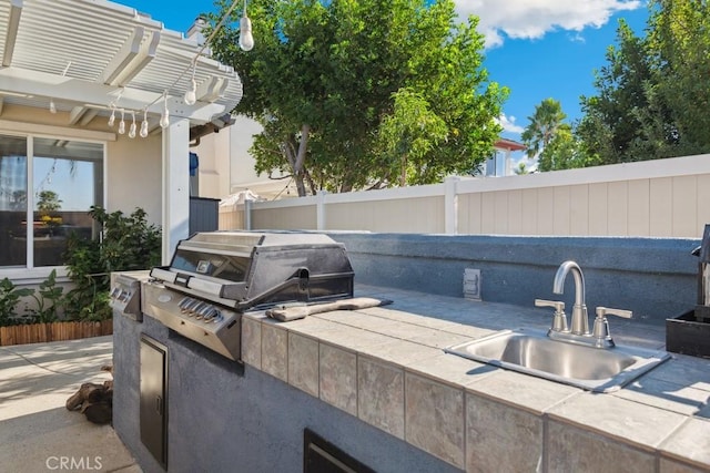 view of patio / terrace featuring a pergola, area for grilling, sink, and an outdoor kitchen