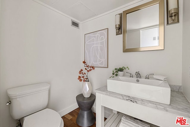 bathroom with wood-type flooring, vanity, and toilet