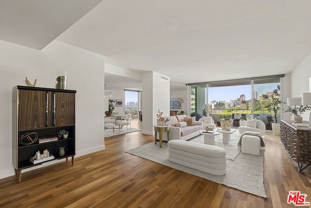 living room with hardwood / wood-style flooring and a wall of windows