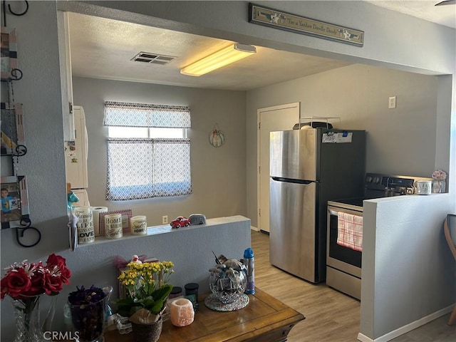 63737 Gibson Rd, Joshua Tree, CA 92252 - kitchen featuring range with electric cooktop, light wood-style flooring, and freestanding refrigerator
