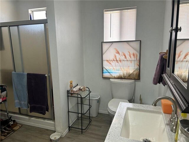 bathroom featuring toilet, a shower with shower door, sink, and hardwood / wood-style floors