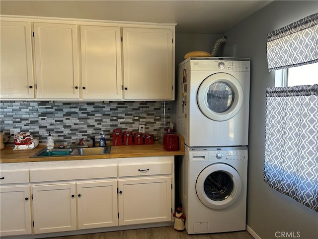 laundry room with stacked washer and clothes dryer and sink