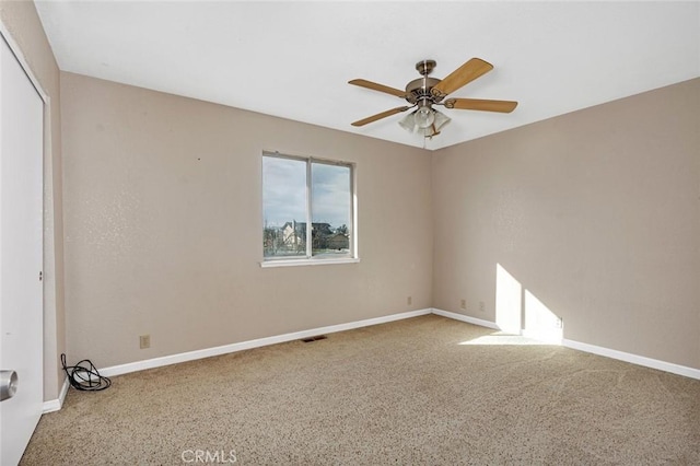 unfurnished room featuring visible vents, a ceiling fan, and baseboards