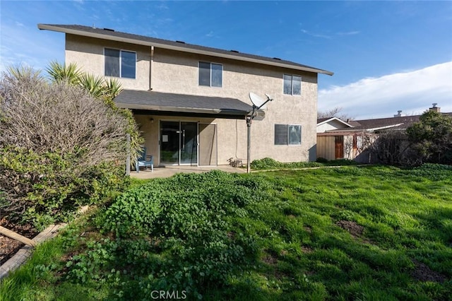 back of house with a patio area, fence, stucco siding, and a yard