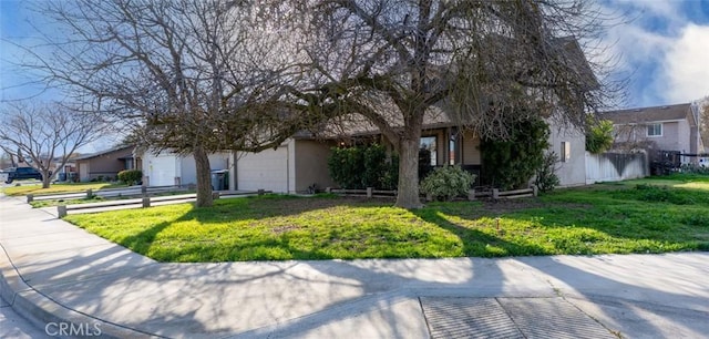 view of property hidden behind natural elements featuring a garage, a front yard, and a residential view