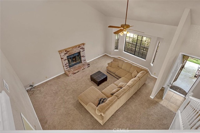 living area featuring high vaulted ceiling, light colored carpet, a brick fireplace, and a healthy amount of sunlight