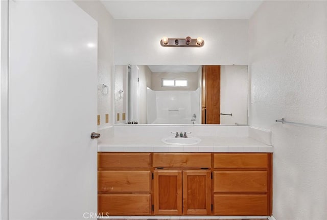 bathroom with a shower and vanity