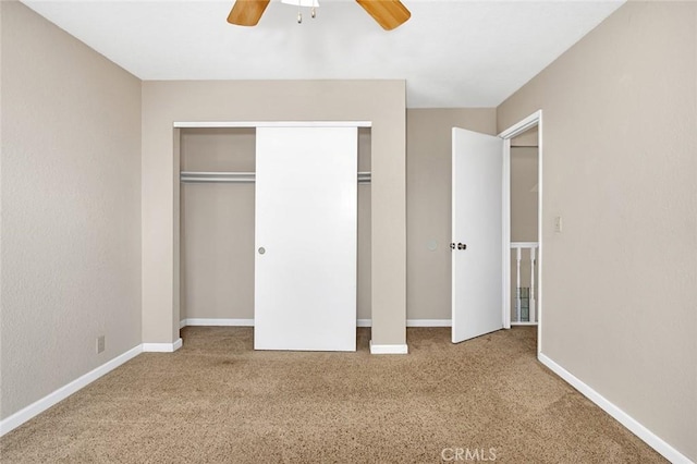 unfurnished bedroom with ceiling fan, a closet, baseboards, and carpet flooring