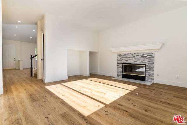 unfurnished living room with a tile fireplace and hardwood / wood-style flooring