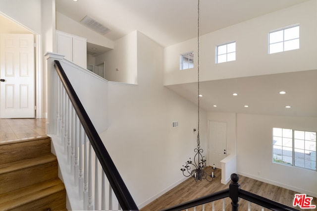 stairway with wood-type flooring and lofted ceiling