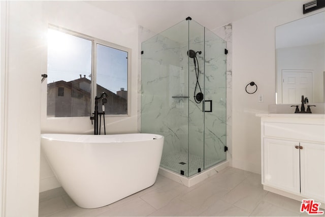 bathroom featuring vanity and independent shower and bath