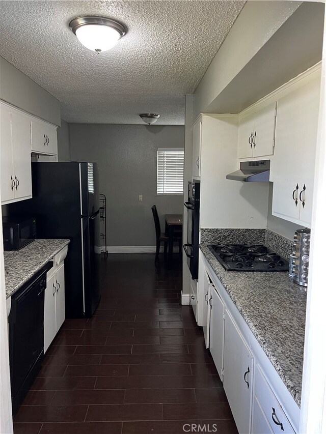 kitchen featuring dark wood-type flooring, a textured ceiling, black appliances, and white cabinetry