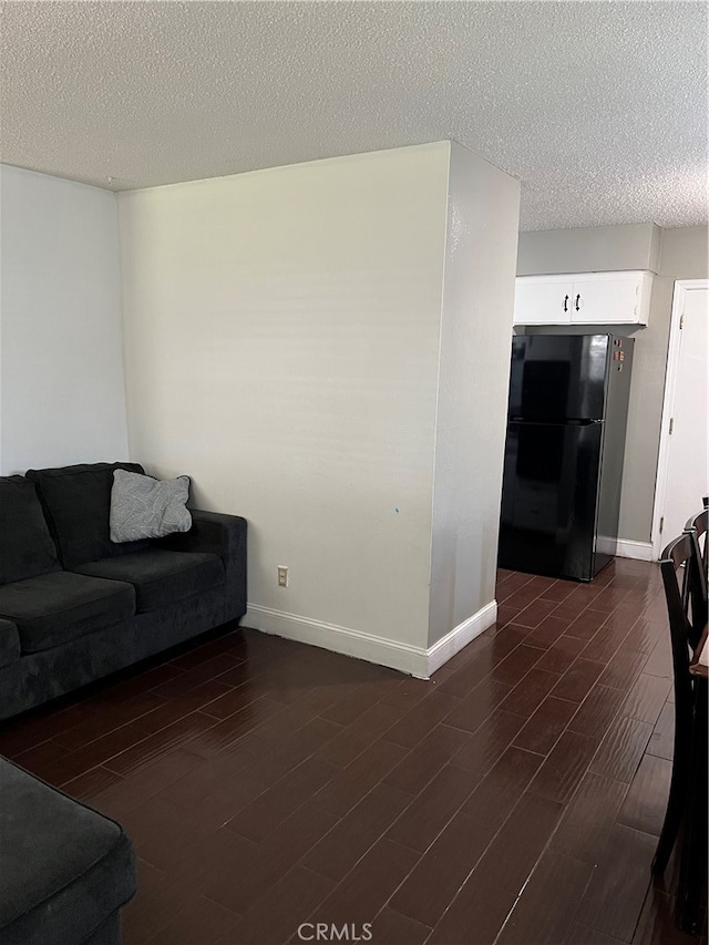 living room featuring a textured ceiling and dark hardwood / wood-style flooring