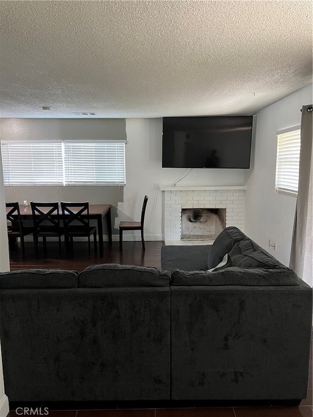 living room featuring a textured ceiling and a fireplace