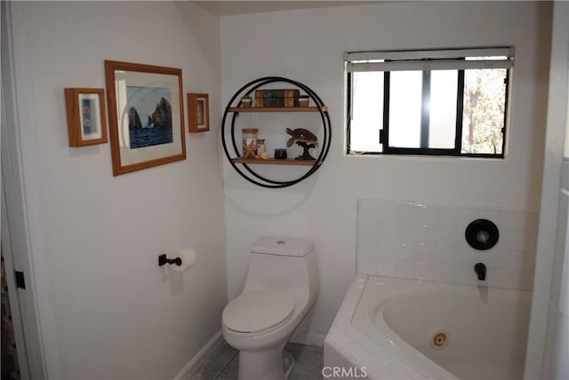 bathroom featuring tile patterned floors, toilet, and tiled tub