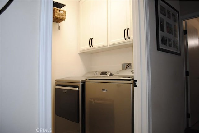 laundry room with cabinets and washing machine and clothes dryer