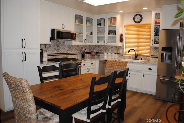 kitchen with white cabinetry, light stone countertops, sink, and appliances with stainless steel finishes