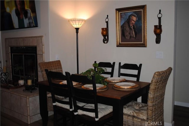 dining area featuring dark hardwood / wood-style flooring and a fireplace