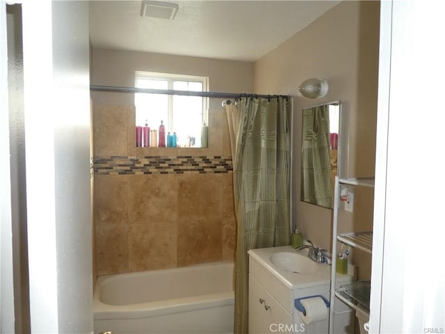 bathroom featuring vanity and shower / bathtub combination with curtain