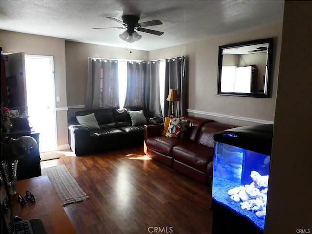 living room featuring ceiling fan, wood-type flooring, and a textured ceiling