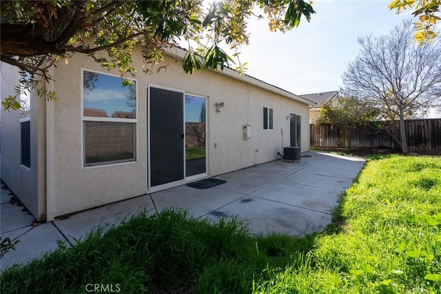 rear view of house featuring fence, a patio, and stucco siding