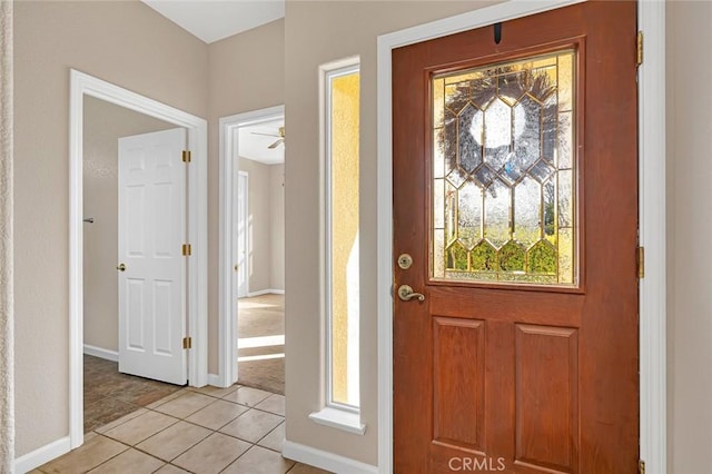 foyer entrance featuring light tile patterned flooring and baseboards