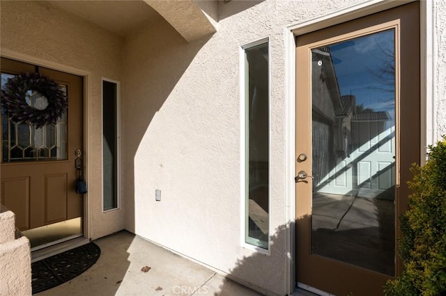 doorway to property featuring stucco siding