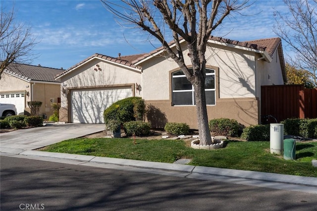 view of front of home with an attached garage, fence, driveway, a tiled roof, and stucco siding