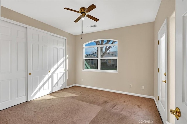 unfurnished bedroom with baseboards, carpet, visible vents, and a closet