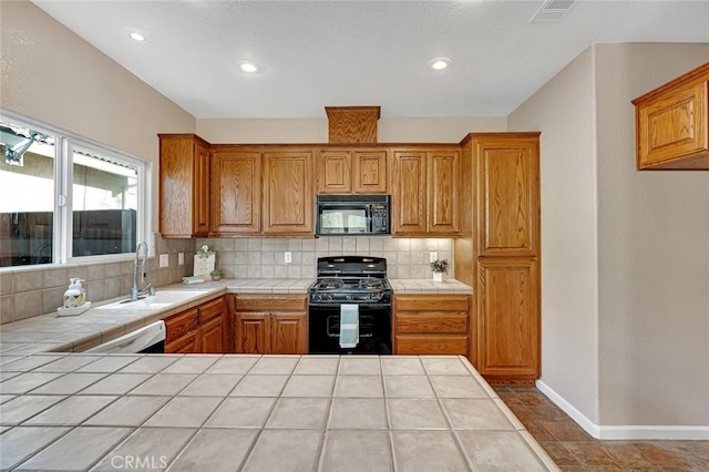 kitchen featuring tasteful backsplash, visible vents, tile countertops, and black appliances