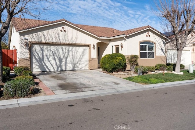 mediterranean / spanish-style home featuring a garage, stucco siding, driveway, and a tiled roof