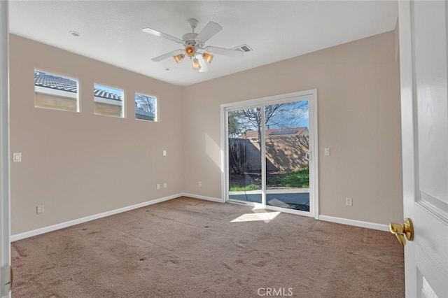 carpeted spare room with baseboards, visible vents, and ceiling fan