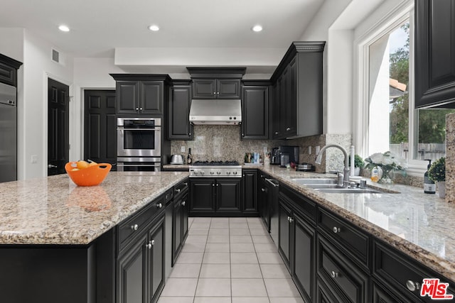 kitchen featuring light stone countertops, sink, stainless steel appliances, tasteful backsplash, and light tile patterned floors