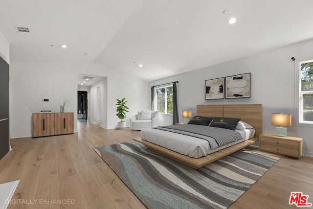 bedroom with light hardwood / wood-style floors and vaulted ceiling