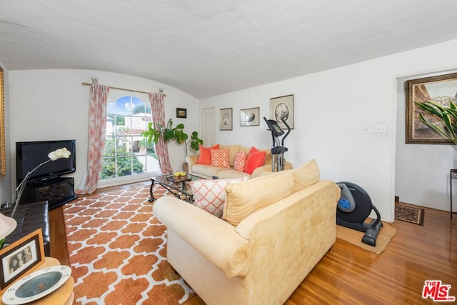 living room featuring lofted ceiling and hardwood / wood-style floors