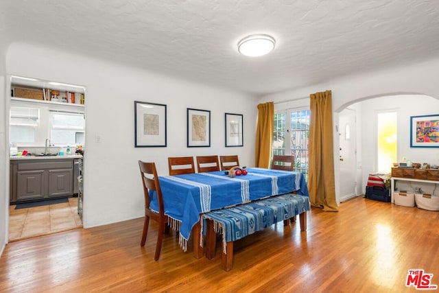 dining space featuring light hardwood / wood-style flooring and a textured ceiling