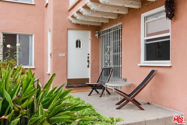 view of exterior entry with a patio area