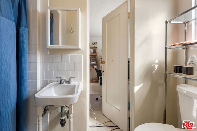 bathroom featuring tile walls, toilet, walk in shower, and tasteful backsplash