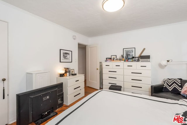 bedroom with crown molding and light hardwood / wood-style floors