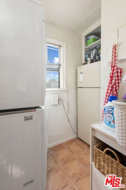 clothes washing area with stacked washer / dryer