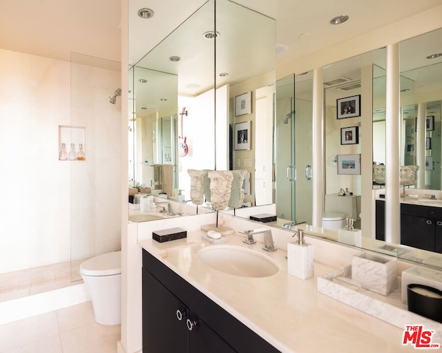 bathroom with vanity, toilet, tile patterned floors, and walk in shower