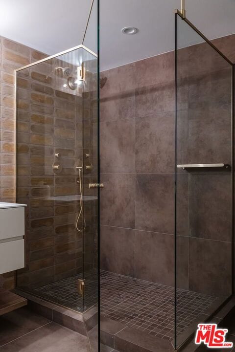 bathroom featuring vanity, tile patterned floors, and walk in shower